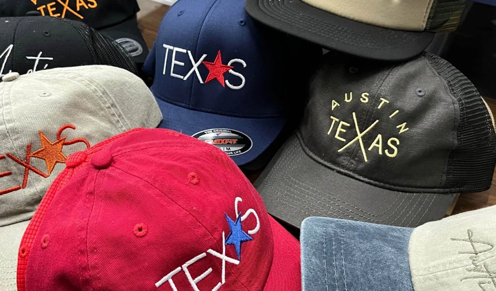 A variety of hats with custom designs printed on them.