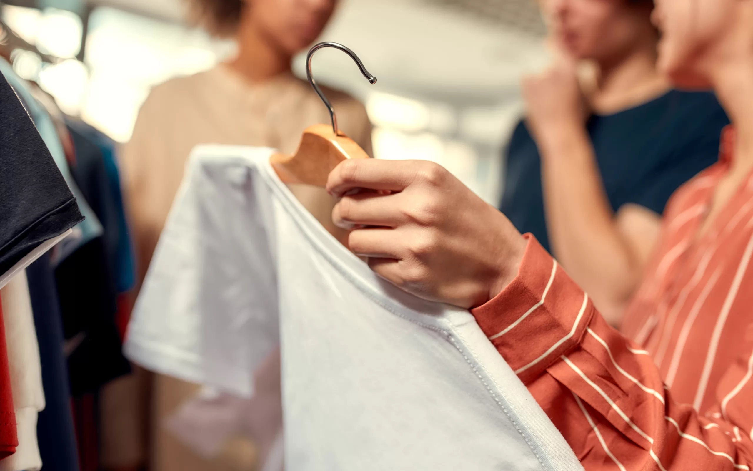 a group of young adult customers are shopping a clothing brand and browsing branded apparel in the store