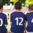 three young boys sitting on the team bench with custom made jerseys