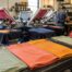 Freshly printed custom t-shirts and a screen printing press at an Austin print shop during a fast turnaround order.