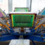 Multi-station screen printing carousel press loaded with colorful mesh screens ready for production, representing the professional custom shirt printing equipment used for no minimum orders at The Logo Store in Austin TX