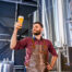 brewer holding up fresh beer at local brewery in austin tx