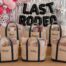 Custom bachelorette party favors including matching shirts, koozies, tumblers, and a tote on a sunny Austin patio table.